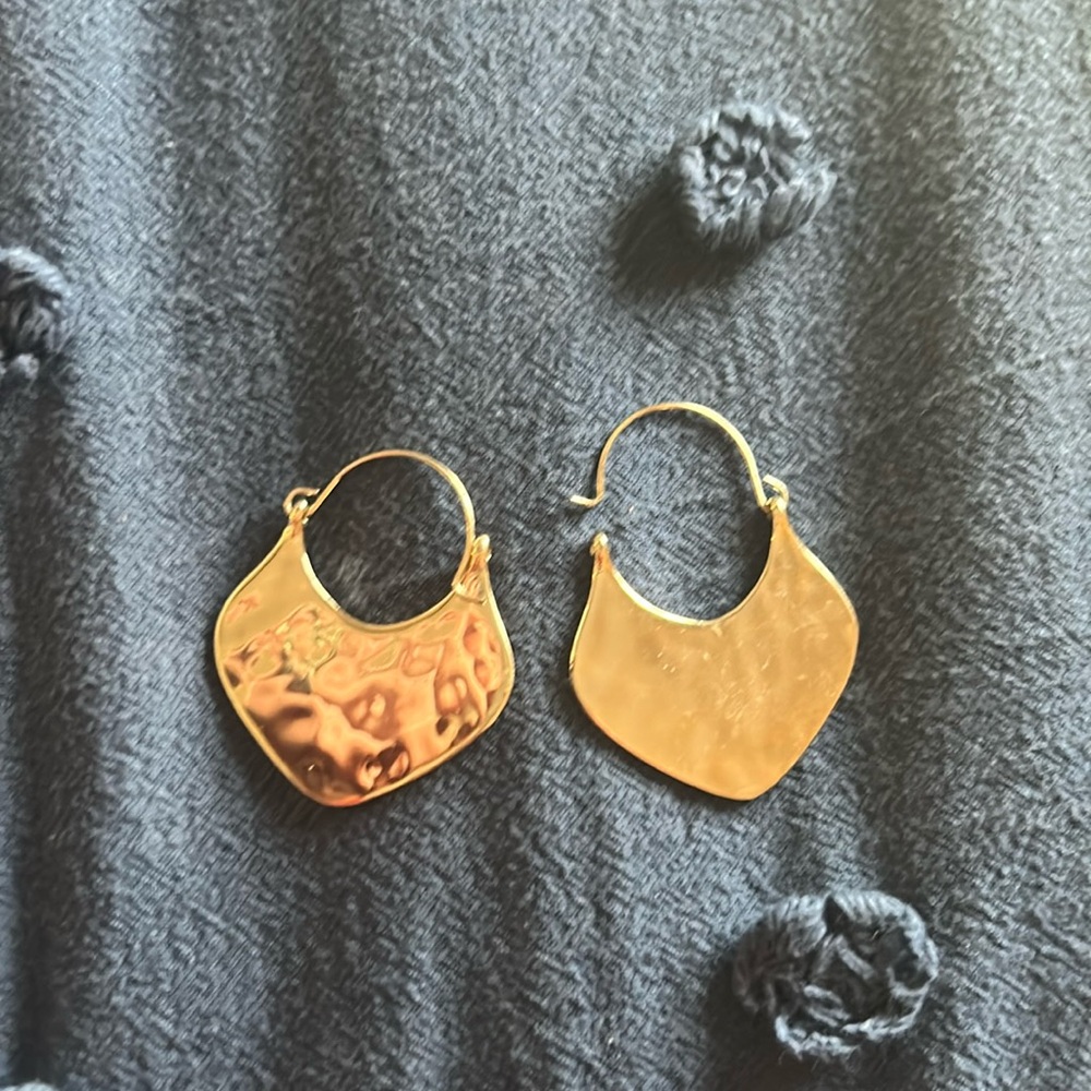 Gold hammered metal hoop earrings.